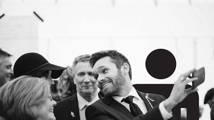 A black and white photo of a group of people clapping