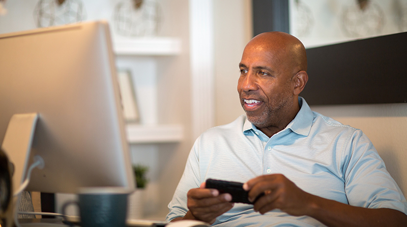 A man watching something on his computer with interest.
