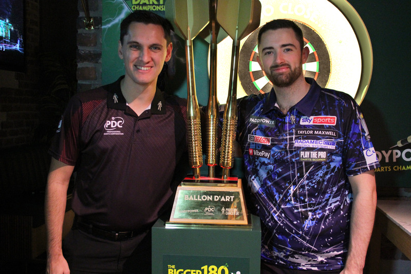 Charlie and world champion Luke Humphries stand either side of the Ballon d'Art trophy