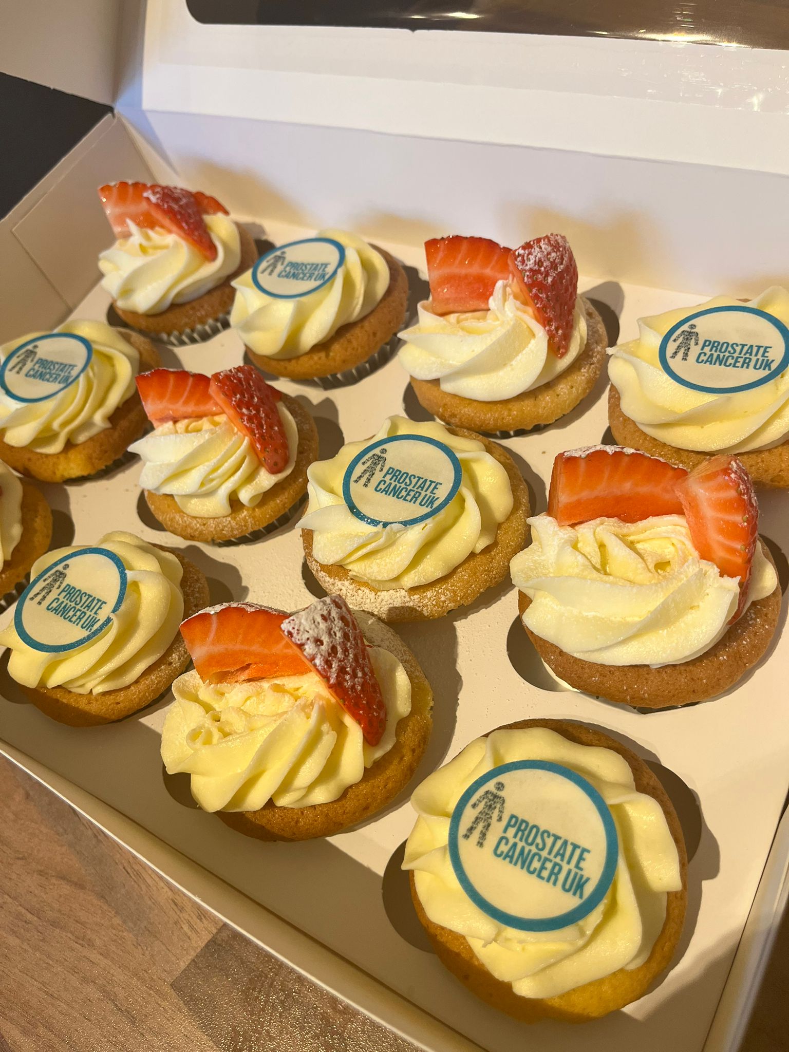 A box of cup cakes with Prostate Cancer UK decorations