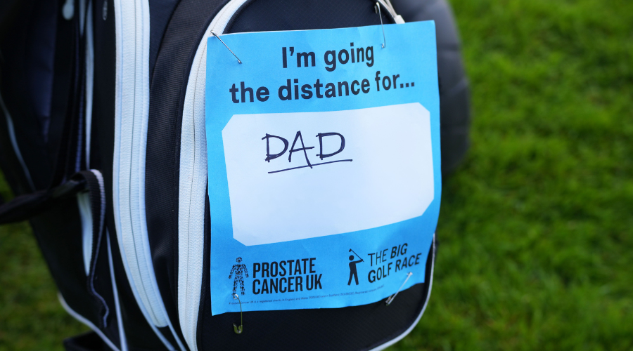 A golf bag covered with a sticker that says 'I'm going the distance for Dad'