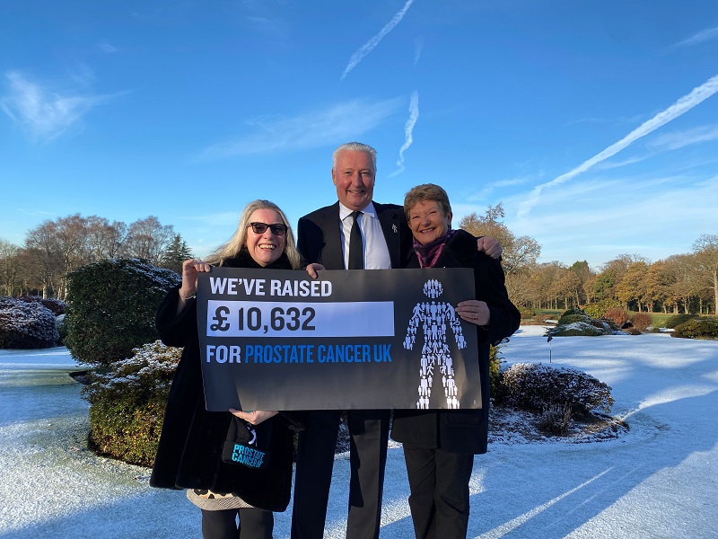 A man and two women showing that they've raised £10,632 in donations for Prostate Cancer UK.