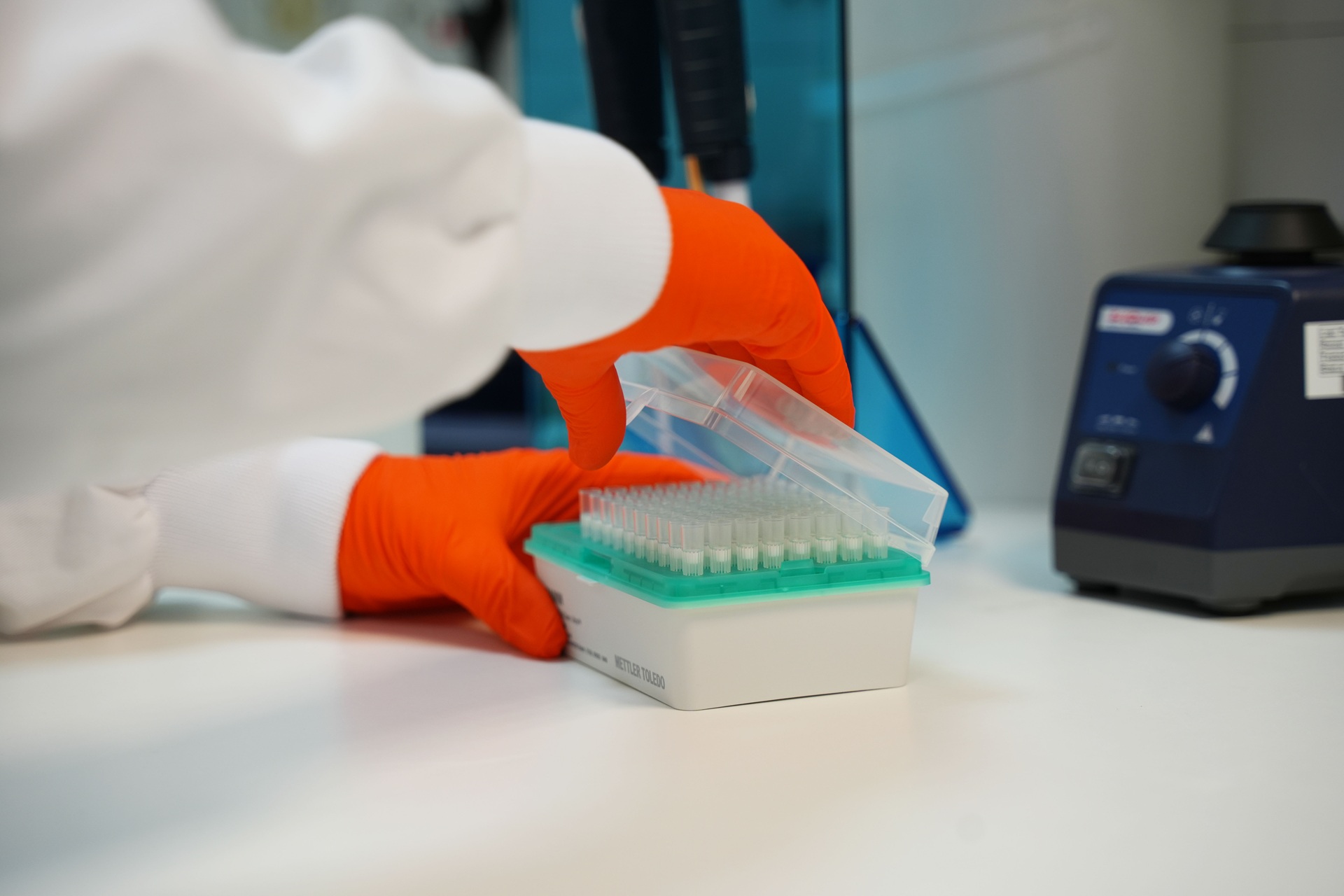A researcher in a lab opening test tubes.
