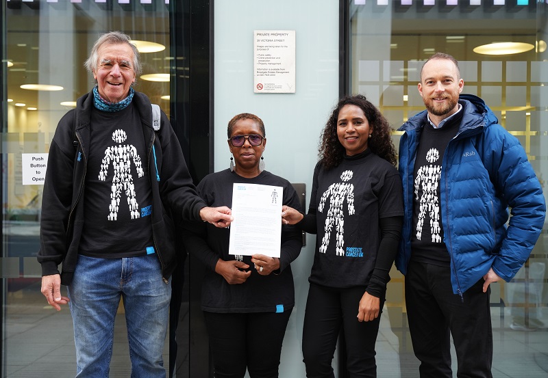 A group of people wearing black Prostate Cancer UK t-shirts standing and smiling at the camera. 