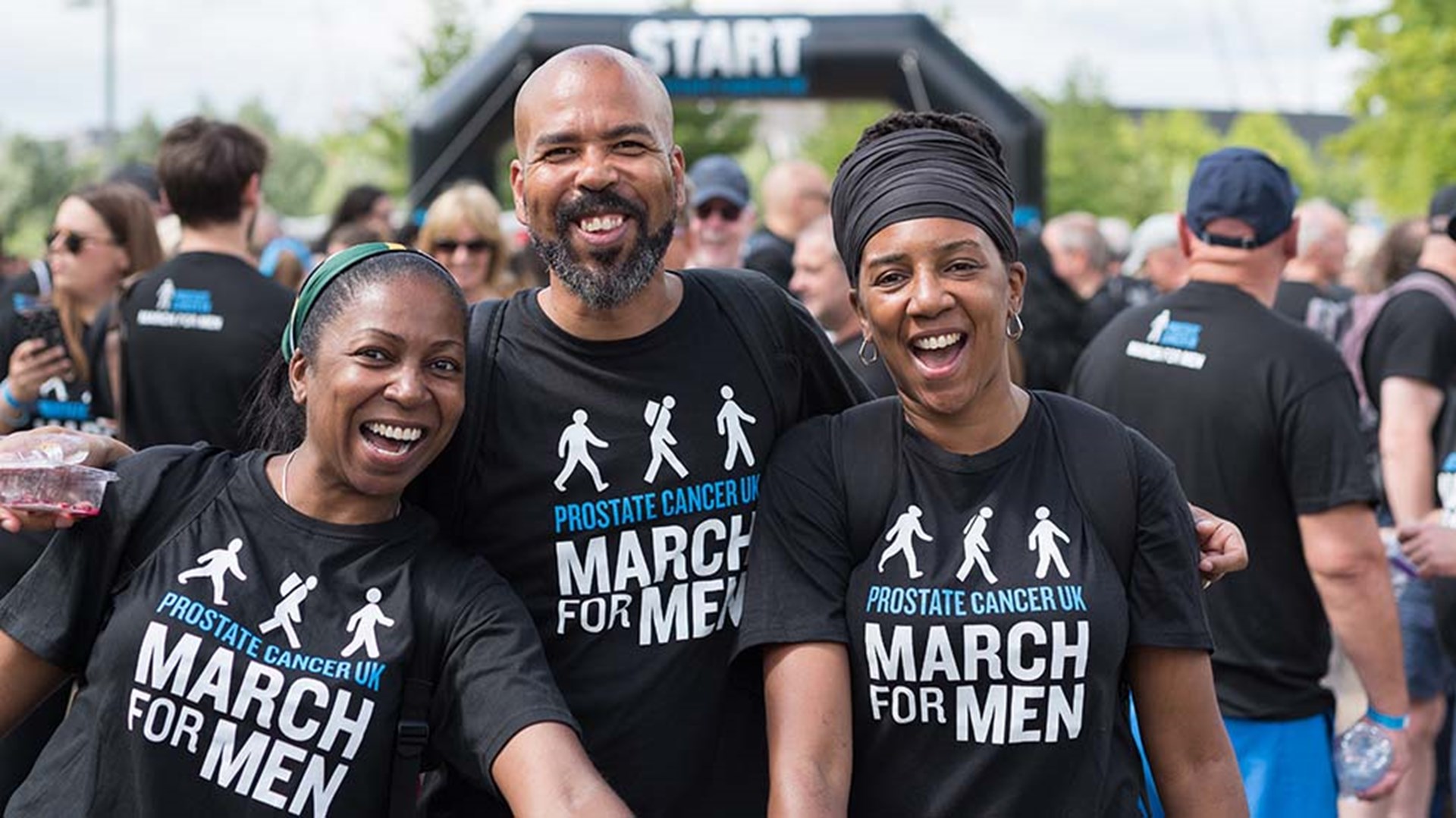 A man and two women celebrate after finishing a sponsored walk event.