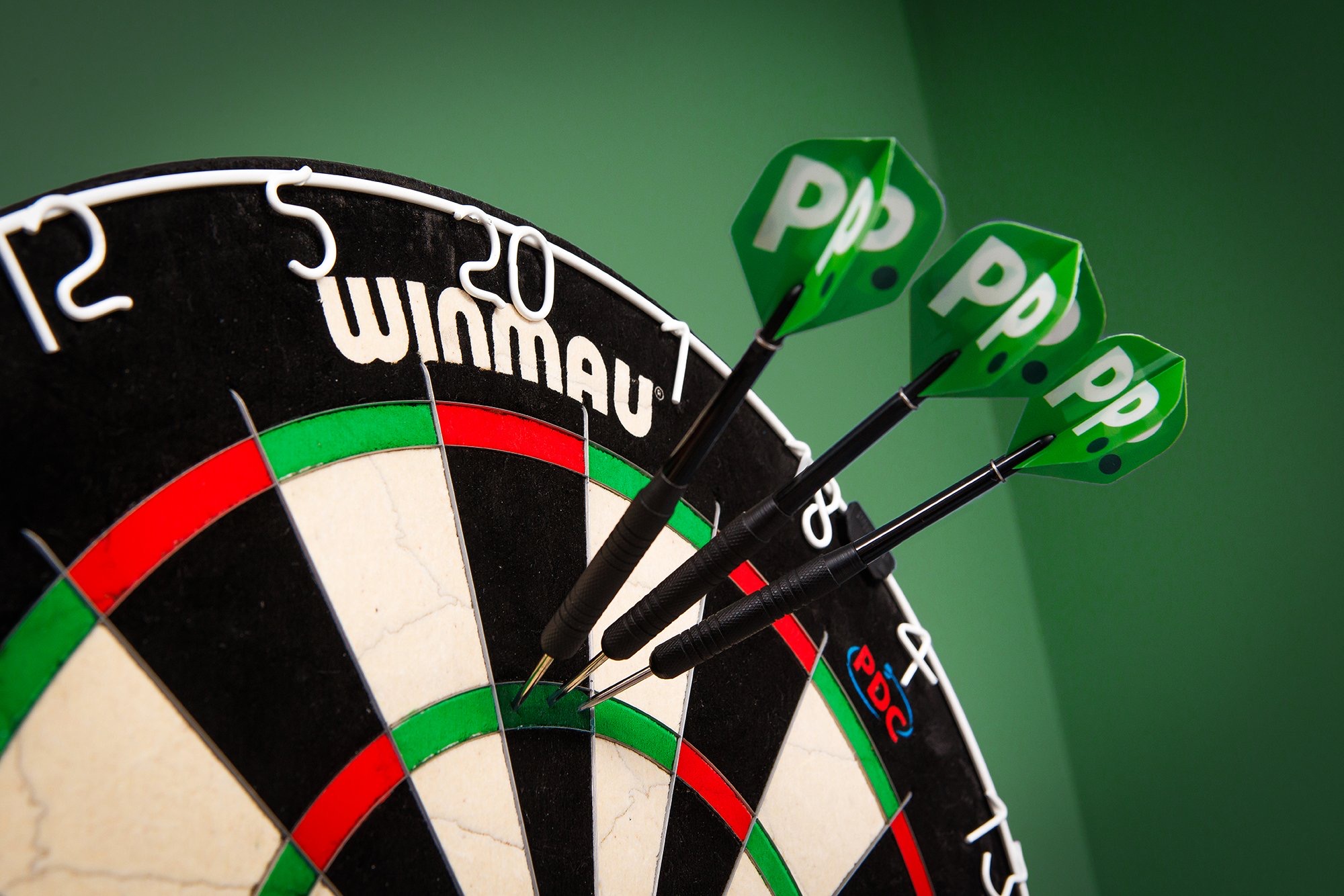 A dart board with three darts stuck in