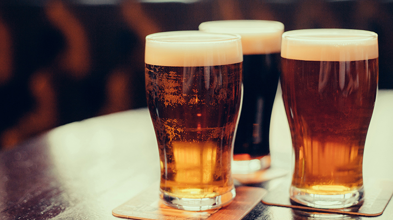 Three pints of beer on a table in a pub