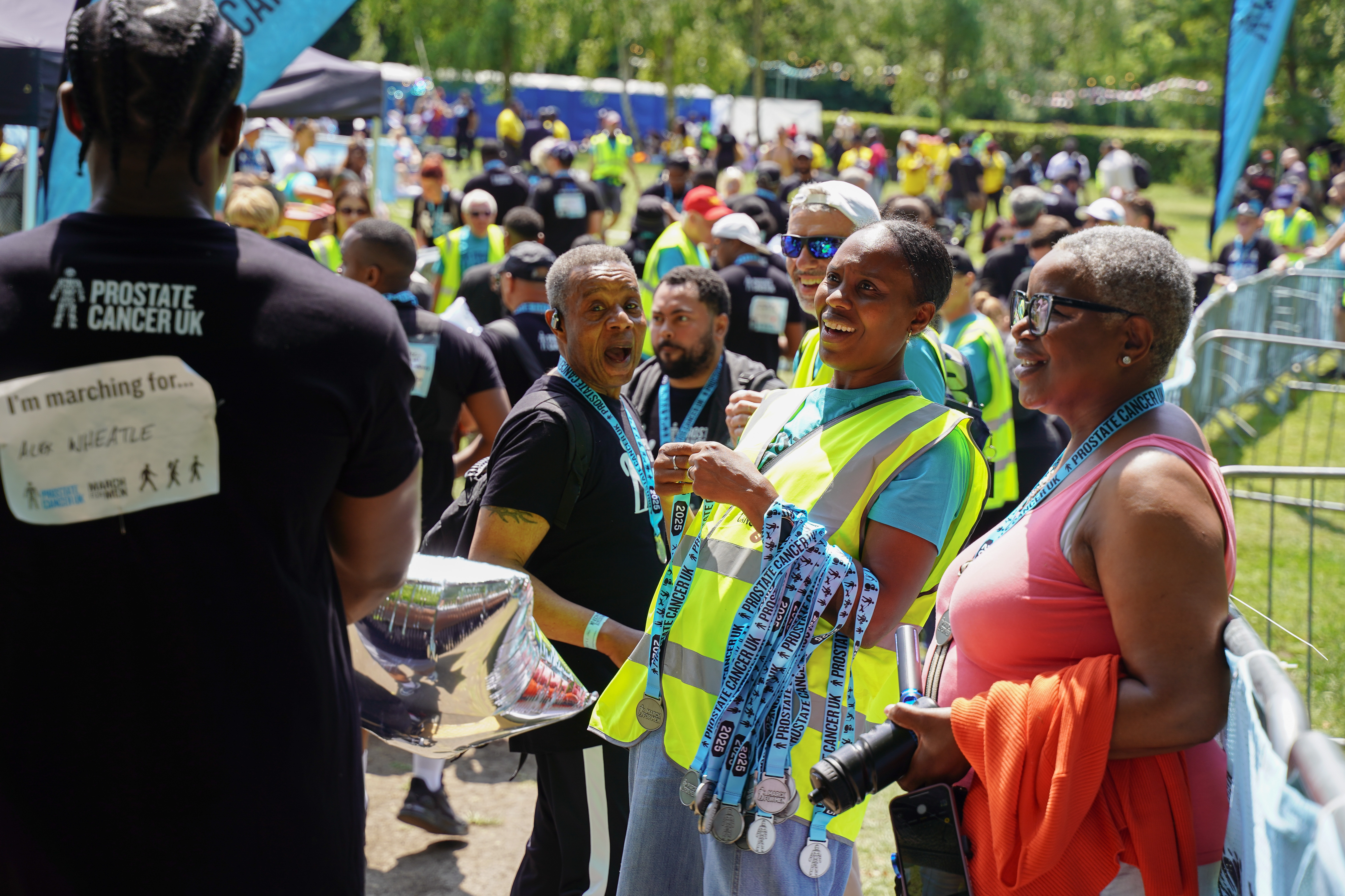 Two women smiling and handing out medals at March for Men. 