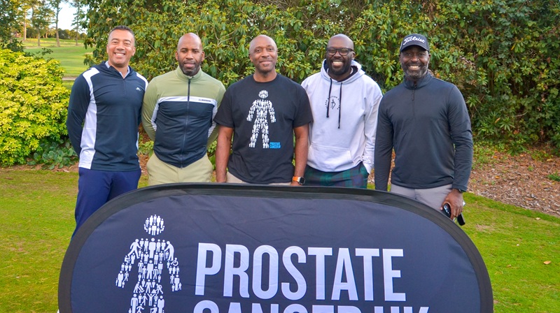 Some of our Black Health Equity team with our celebrity supports standing behind a Prostate Cancer UK banner at our first Black Community Golf day.