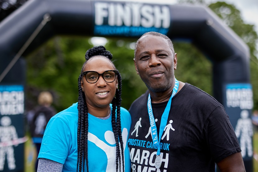 Two people standing next to each other and smiling at the camera at March for Men. 
