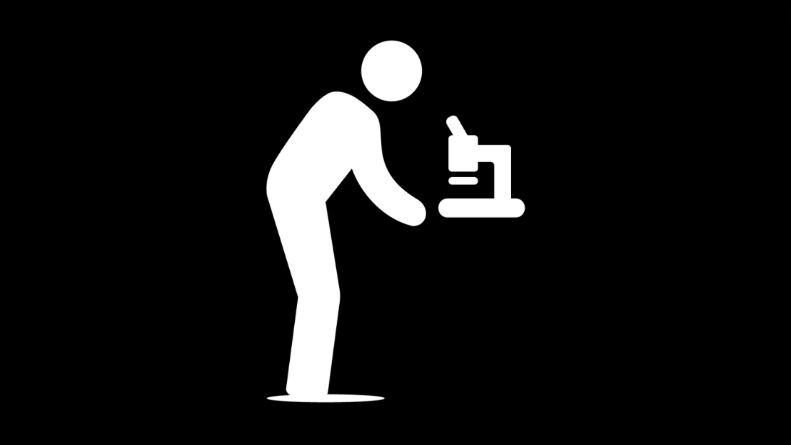A man icon bending down to look into a microscope, on a black background