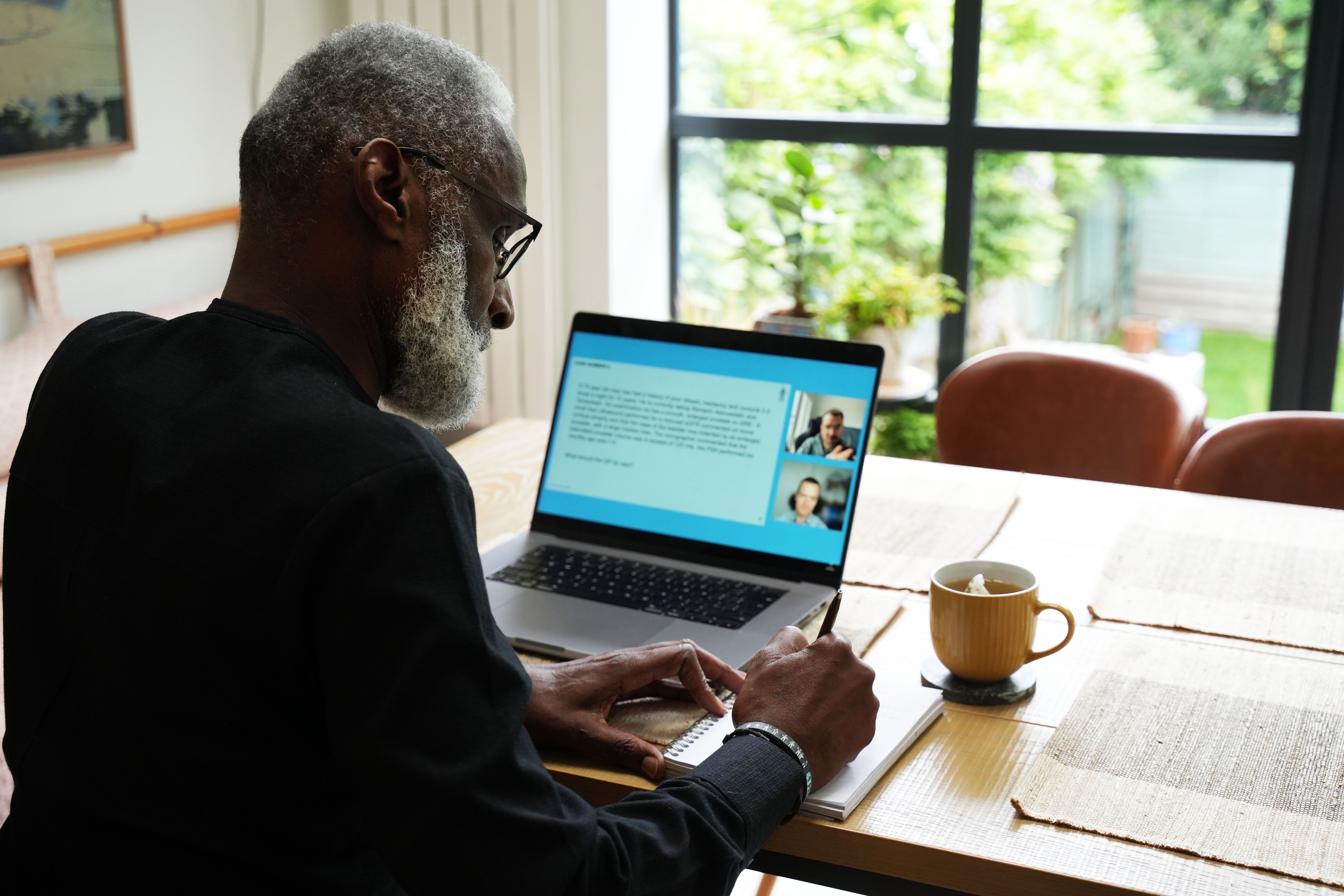 man writing notes for a meeting on a laptop