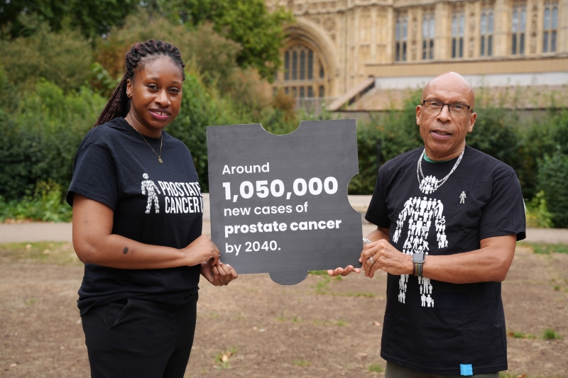 Supporter Des and staff member Essie outside Houses of Parliament holding sign.jpg