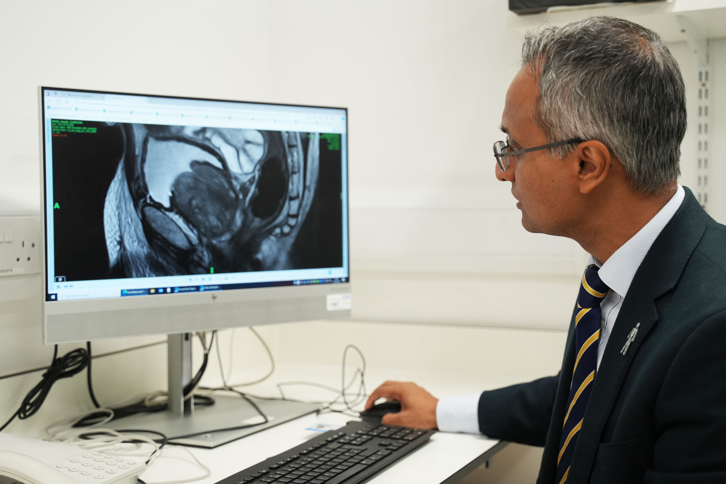 Prof Hashim Ahmed, one of the TRANSFORM research leads, looks at a graphic on a computer screen and moves a mouse with his hand