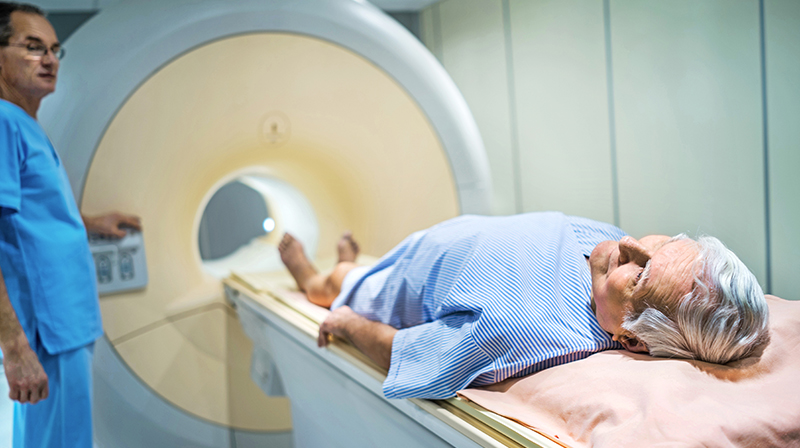 A man lying on a hospital trolley about to undergo an MRI