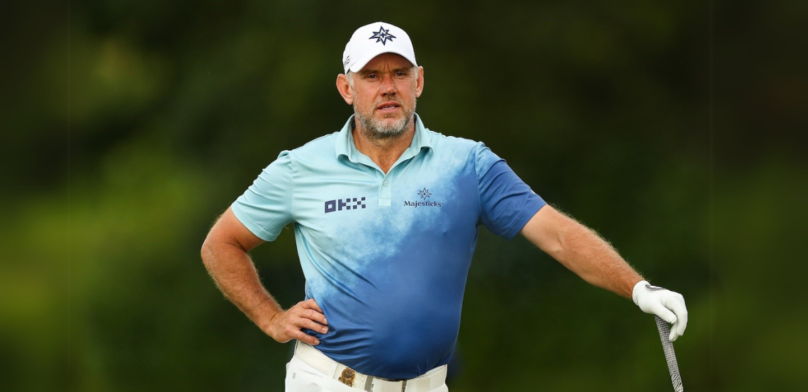 Former World No. 1 golfer Lee Westwood out on the course, leaning on a golf club with one hand on his hip