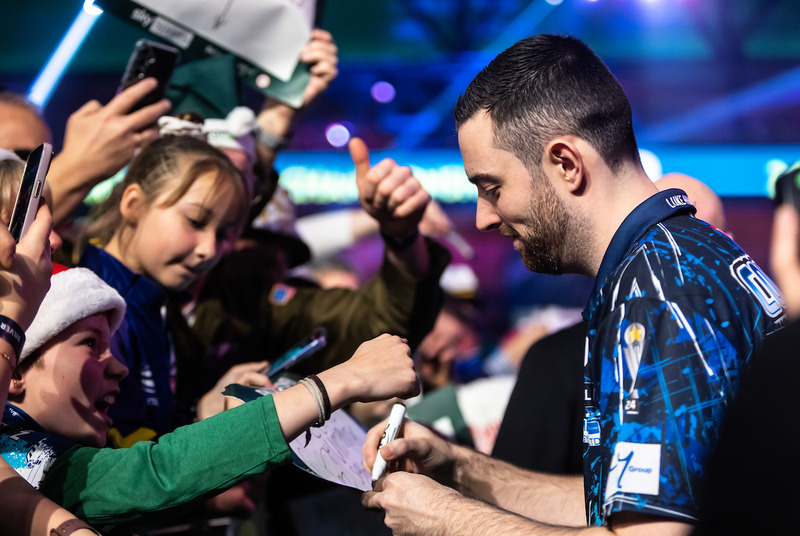 Luke Humphries stops to sign autographs for young fans during his pre-match walk-on at Alexandra Palace.
