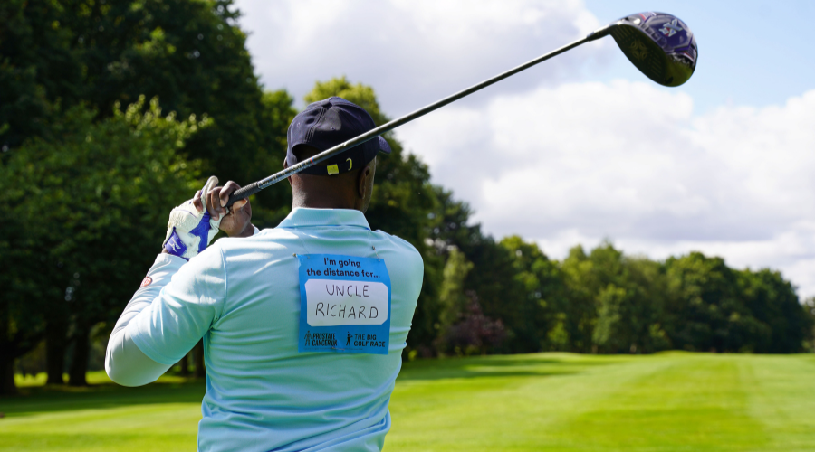 A golfer taking a swing, with a message about prostate cancer written on the back of his shirt